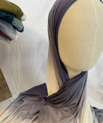 Hijab en jersey lycra avec un dégradé de couleurs allant du gris ardoise foncé au crème clair, présenté sur un mannequin.