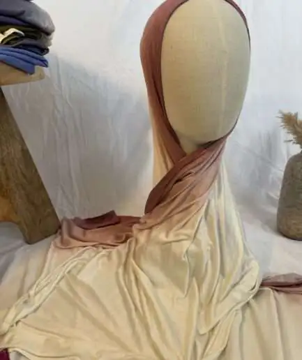 Hijab en jersey lycra avec un dégradé de couleurs allant du vieux rose au crème, présenté sur un mannequin.