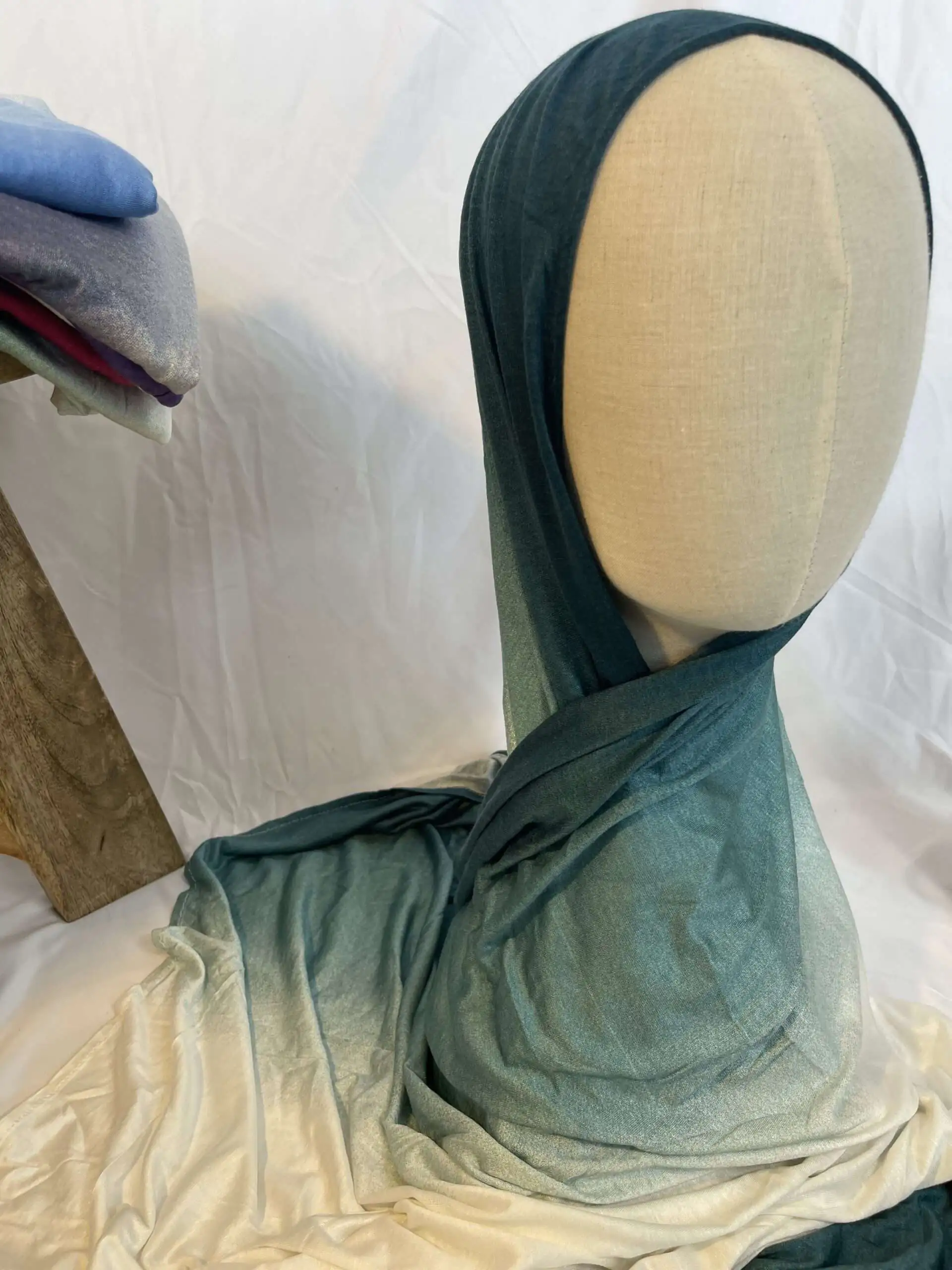 Hijab en jersey lycra avec un d&eacute;grad&eacute; de couleurs allant du bleu canard profond au cr&egrave;me clair, pr&eacute;sent&eacute; sur un mannequin.