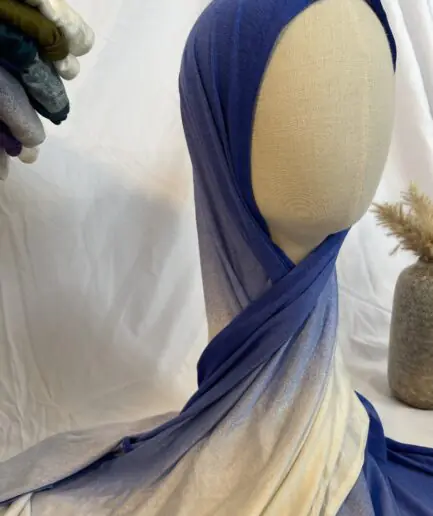 Hijab en jersey lycra avec un dégradé de couleurs allant du bleu roi vibrant au crème clair, présenté sur un mannequin.