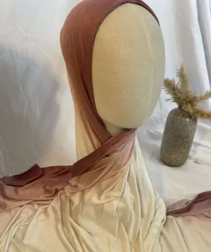 Hijab en jersey lycra avec un dégradé de couleurs allant du vieux rose au crème, présenté sur un mannequin.