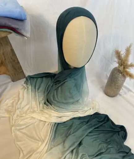 Hijab en jersey lycra avec un dégradé de couleurs allant du bleu canard profond au crème clair, présenté sur un mannequin.