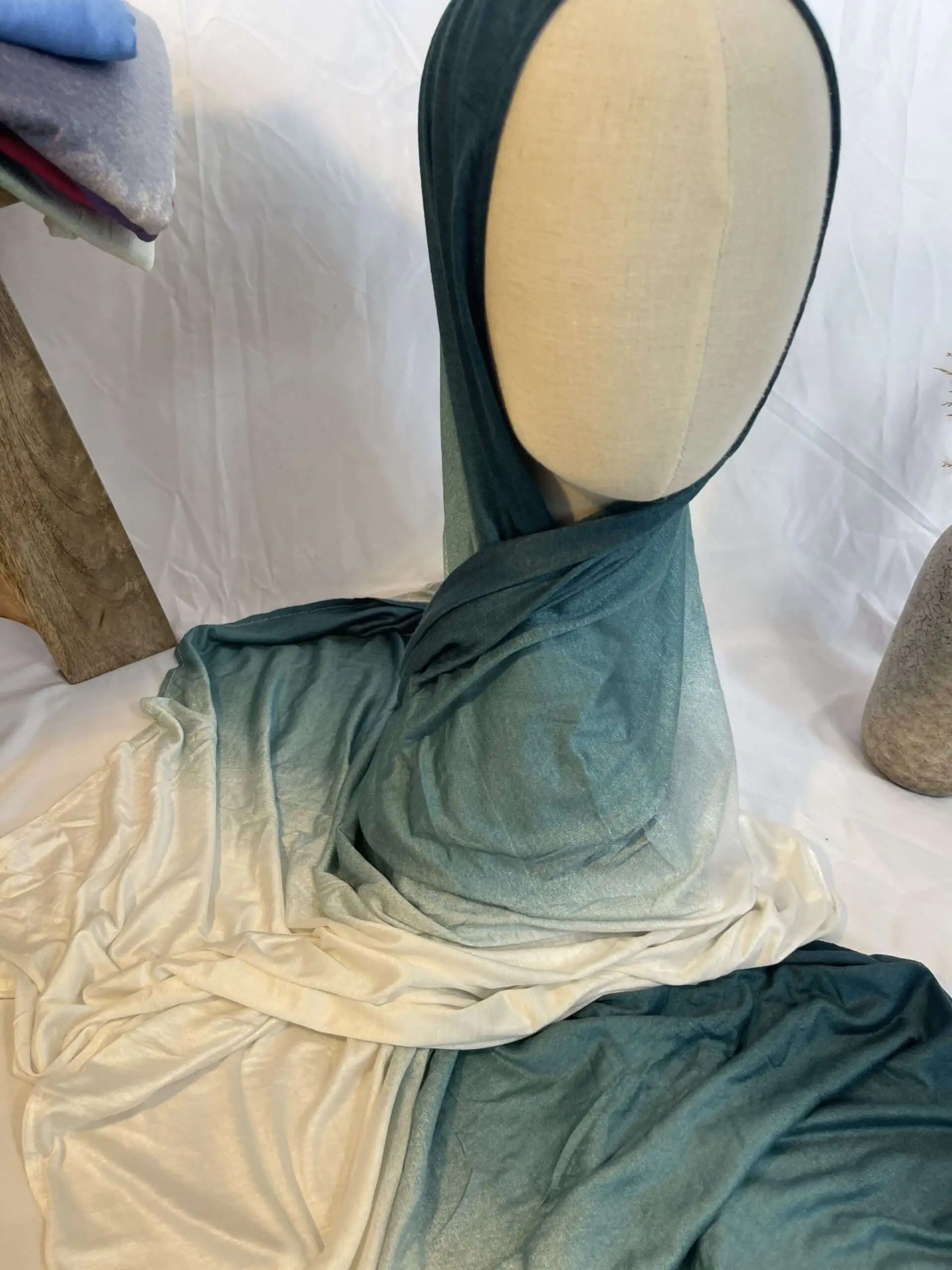 Hijab en jersey lycra avec un d&eacute;grad&eacute; de couleurs allant du bleu canard profond au cr&egrave;me clair, pr&eacute;sent&eacute; sur un mannequin.