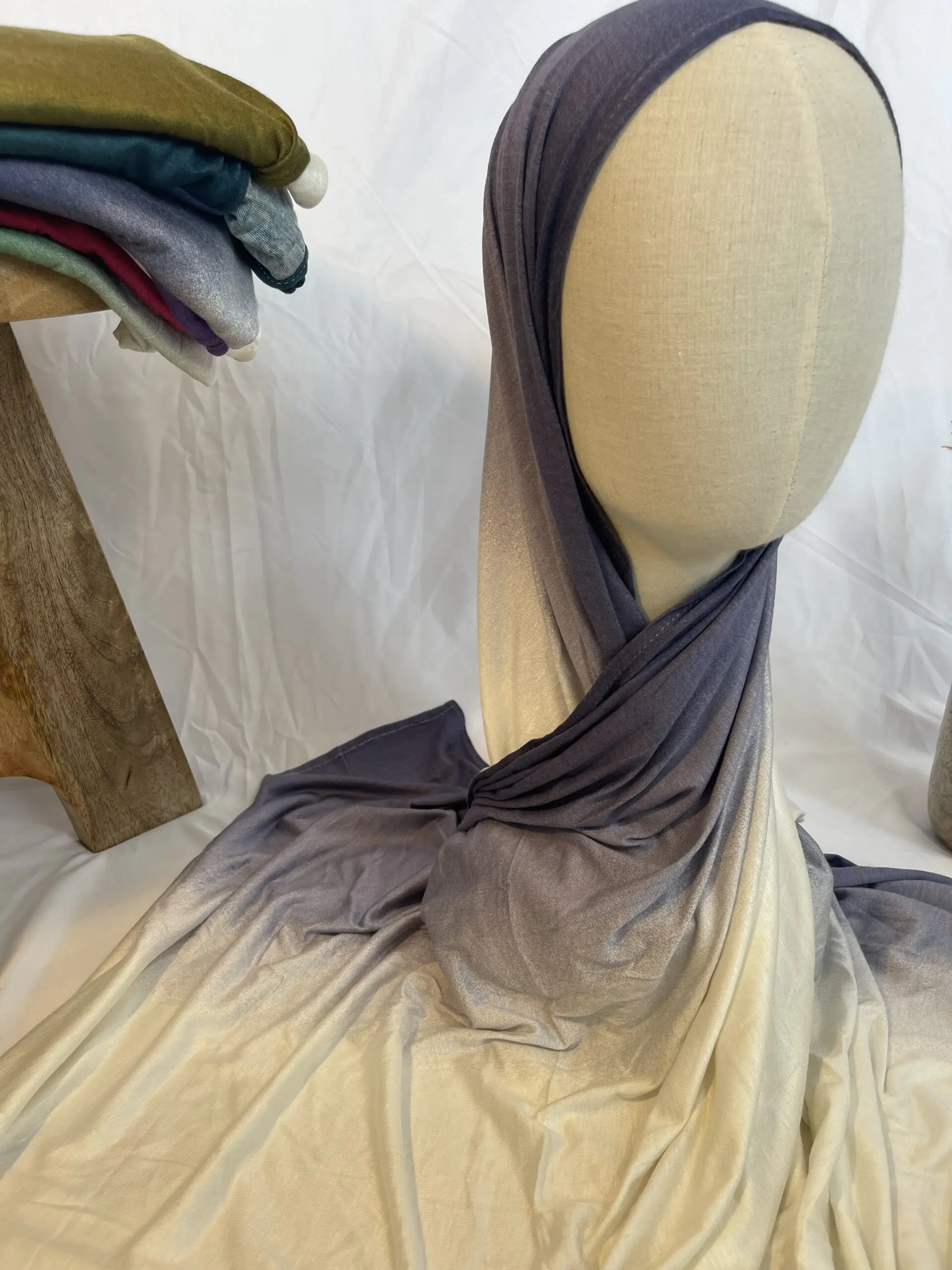 Hijab en jersey lycra avec un d&eacute;grad&eacute; de couleurs allant du gris ardoise fonc&eacute; au cr&egrave;me clair, pr&eacute;sent&eacute; sur un mannequin.