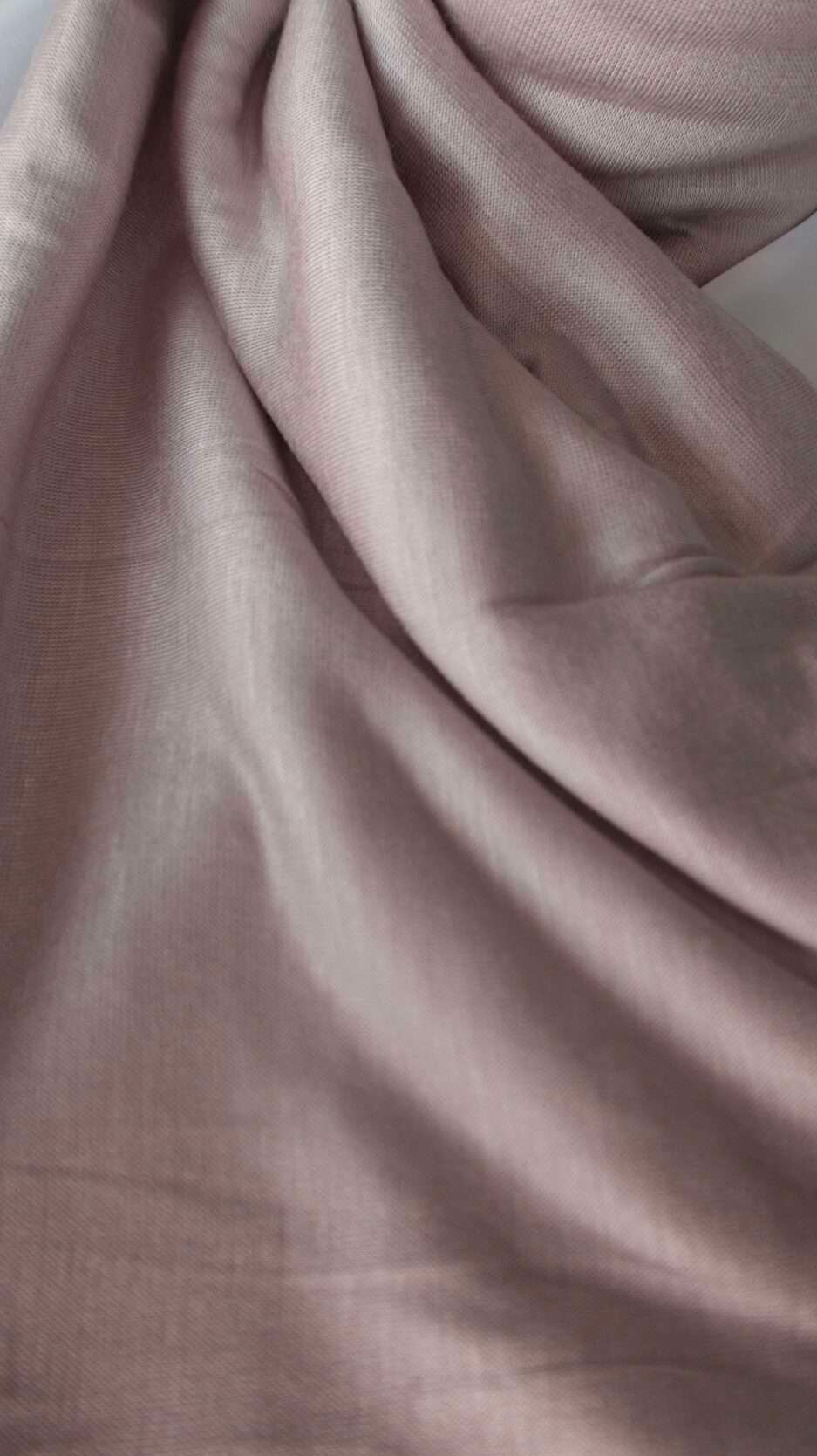 Hijab uni rose poudré délicat en jersey Dubai premium (coton de haute qualité), montrant sa texture douce et son drapé, porté et roulé.