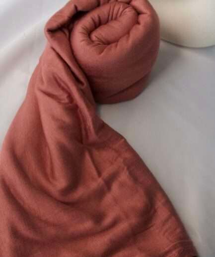 Hijab uni terracotta rosé en jersey Dubai premium (coton de haute qualité), montrant sa texture douce et son drapé, porté et roulé.