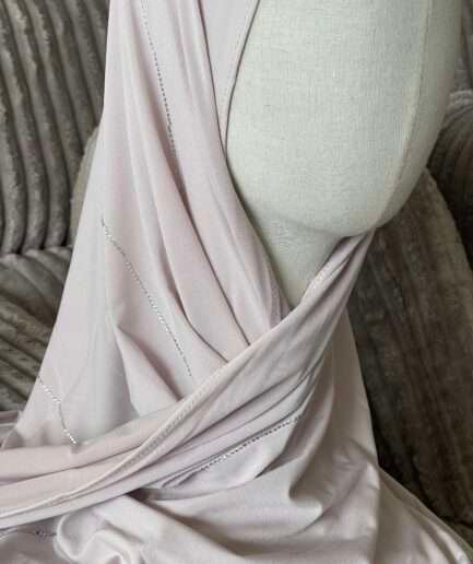 Hijab rose poudré clair en jersey doux avec de fines lignes de strass argentés scintillants, présenté sur un mannequin.