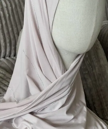Hijab rose poudr&eacute; clair en jersey doux avec de fines lignes de strass argent&eacute;s scintillants, pr&eacute;sent&eacute; sur un mannequin.