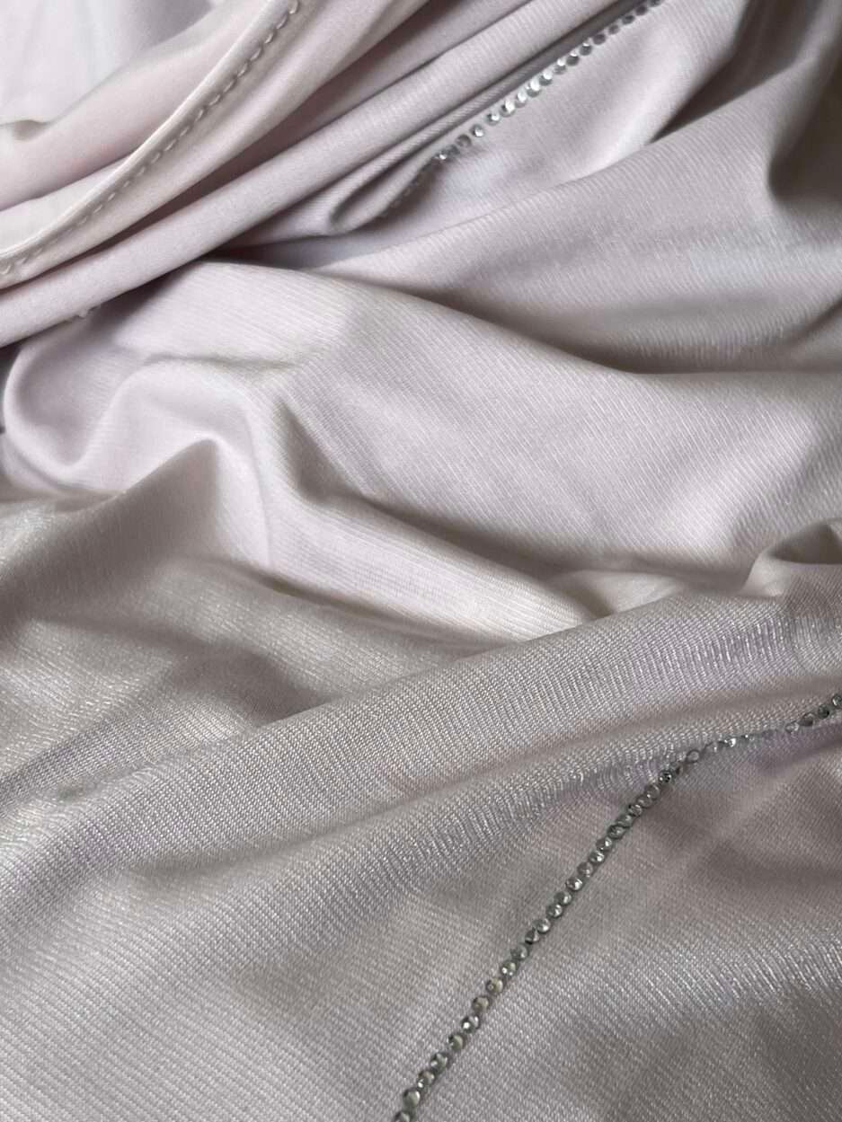 Hijab rose poudré clair en jersey doux avec de fines lignes de strass argentés scintillants, présenté sur un mannequin.
