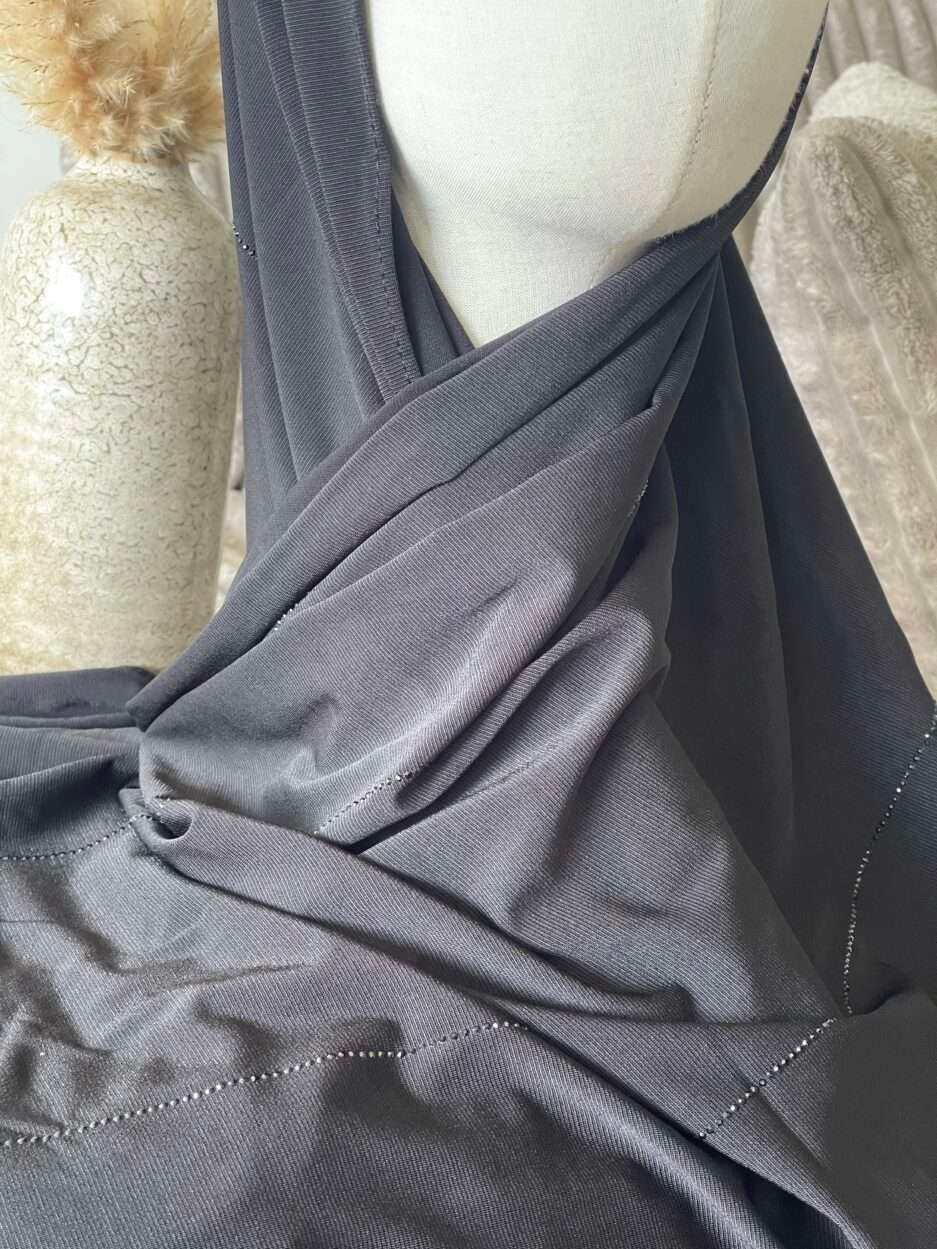 Hijab noir profond en jersey doux avec de fines lignes de strass foncés scintillants, présenté sur un mannequin.