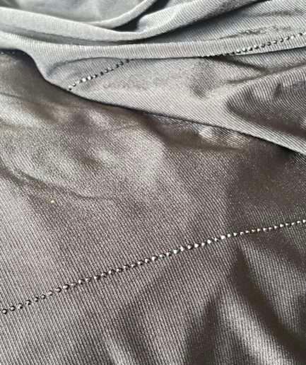 Hijab noir profond en jersey doux avec de fines lignes de strass foncés scintillants, présenté sur un mannequin.