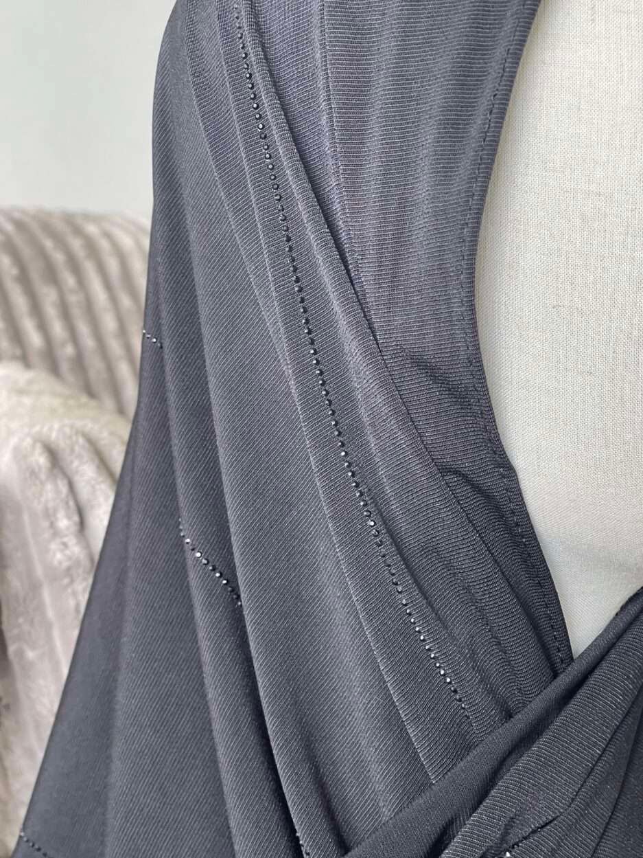 Hijab noir profond en jersey doux avec de fines lignes de strass foncés scintillants, présenté sur un mannequin.