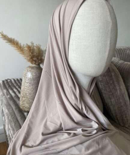 Hijab beige nude clair en jersey doux avec de fines lignes de strass argentés scintillants, présenté sur un mannequin.
