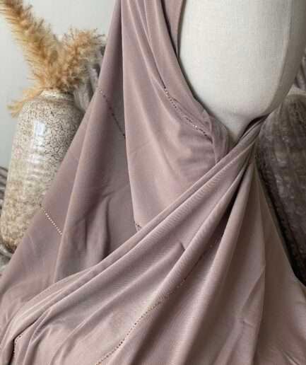 Hijab taupe rosé en jersey doux avec de fines lignes de strass dorés scintillants, présenté sur un mannequin.