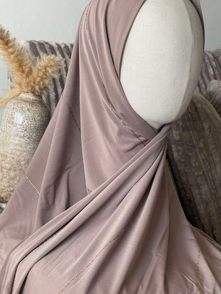 Hijab taupe rosé en jersey doux avec de fines lignes de strass dorés scintillants, présenté sur un mannequin.