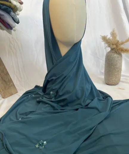 Hijab bleu canard uni en jersey doux, orn&eacute; de broches de perles et strass assortis, pr&eacute;sent&eacute; sur un mannequin.