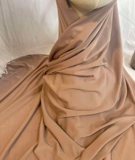 Hijab nude rosé en jersey doux avec une fine bordure décorative, présenté sur un mannequin.