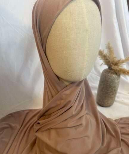 Hijab nude rosé en jersey doux avec une fine bordure décorative, présenté sur un mannequin.