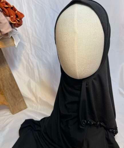 Hijab noir uni en jersey doux avec une fine bordure festonnée décorative, présenté sur un mannequin.