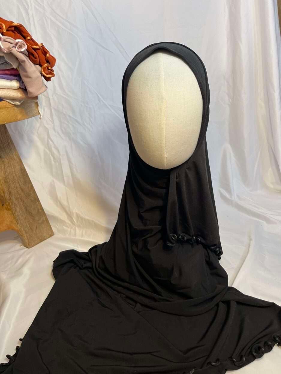 Hijab noir uni en jersey doux avec une fine bordure festonnée décorative, présenté sur un mannequin.