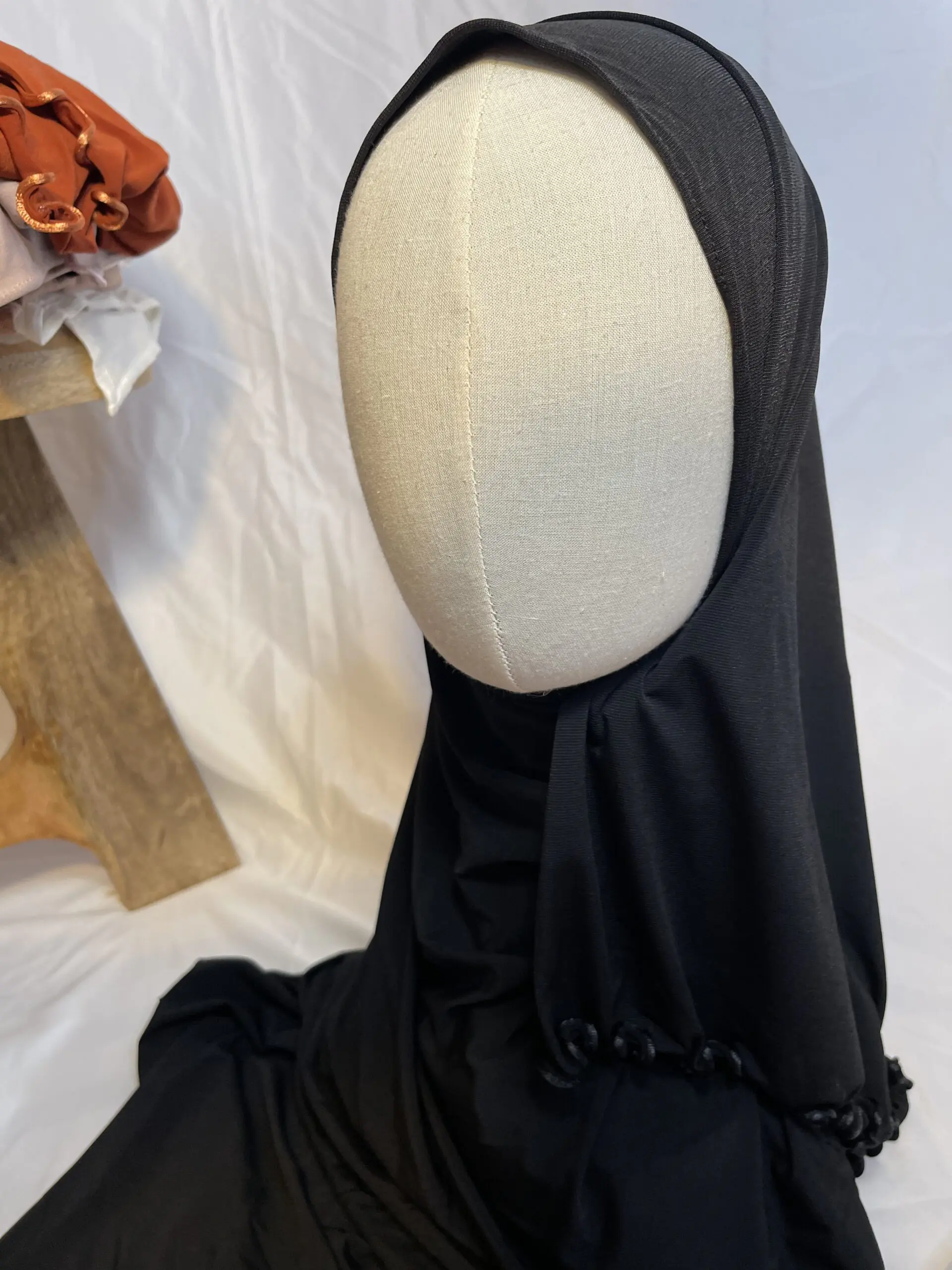 Hijab noir uni en jersey doux avec une fine bordure festonn&eacute;e d&eacute;corative, pr&eacute;sent&eacute; sur un mannequin.