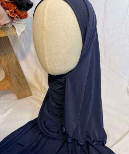 Hijab bleu marine uni en jersey doux avec une fine bordure festonnée décorative, présenté sur un mannequin.