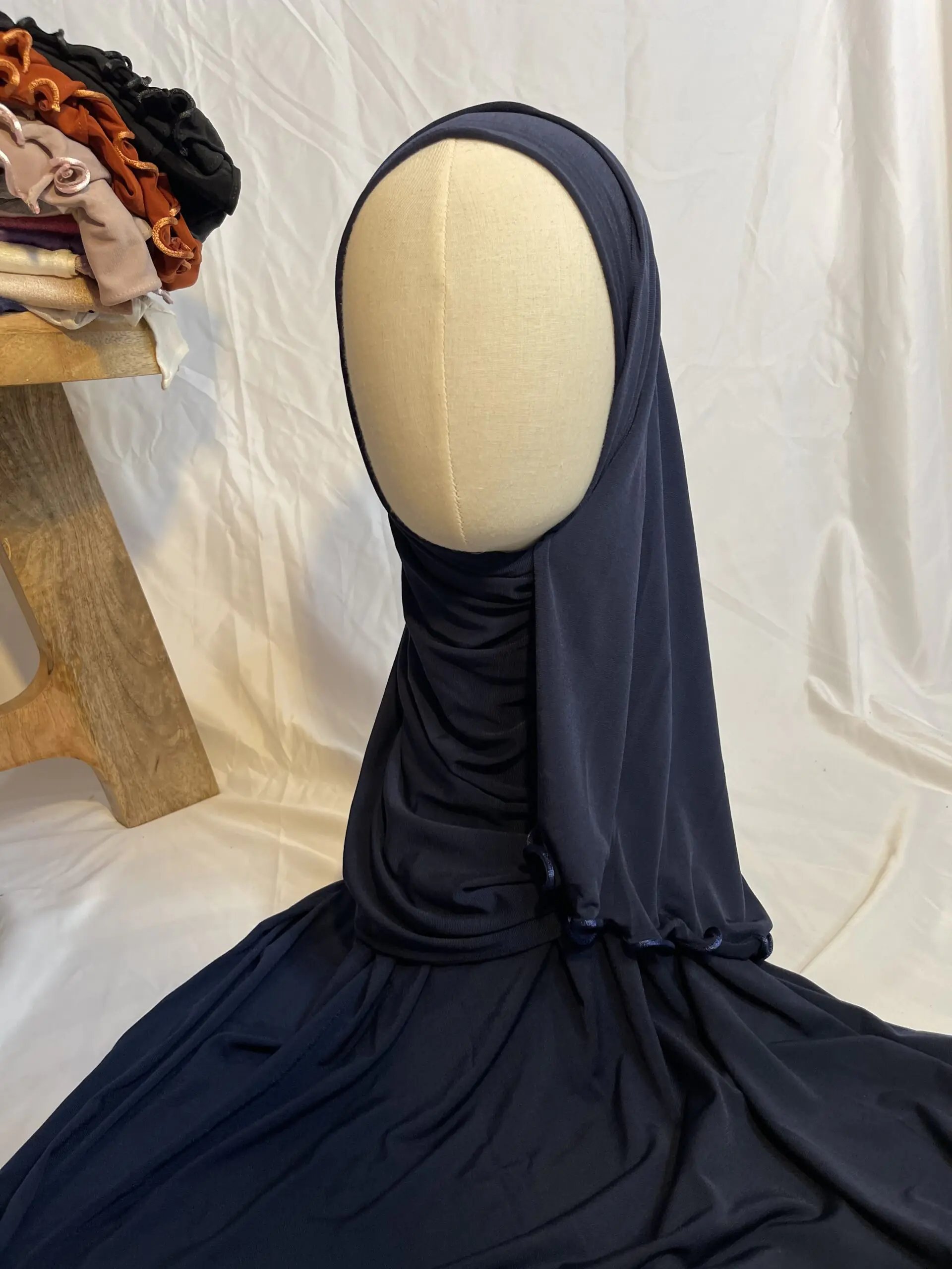 Hijab bleu marine uni en jersey doux avec une fine bordure festonn&eacute;e d&eacute;corative, pr&eacute;sent&eacute; sur un mannequin.
