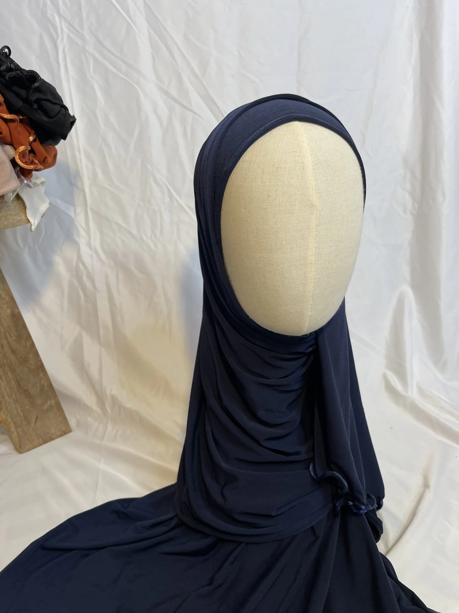 Hijab bleu marine uni en jersey doux avec une fine bordure festonn&eacute;e d&eacute;corative, pr&eacute;sent&eacute; sur un mannequin.