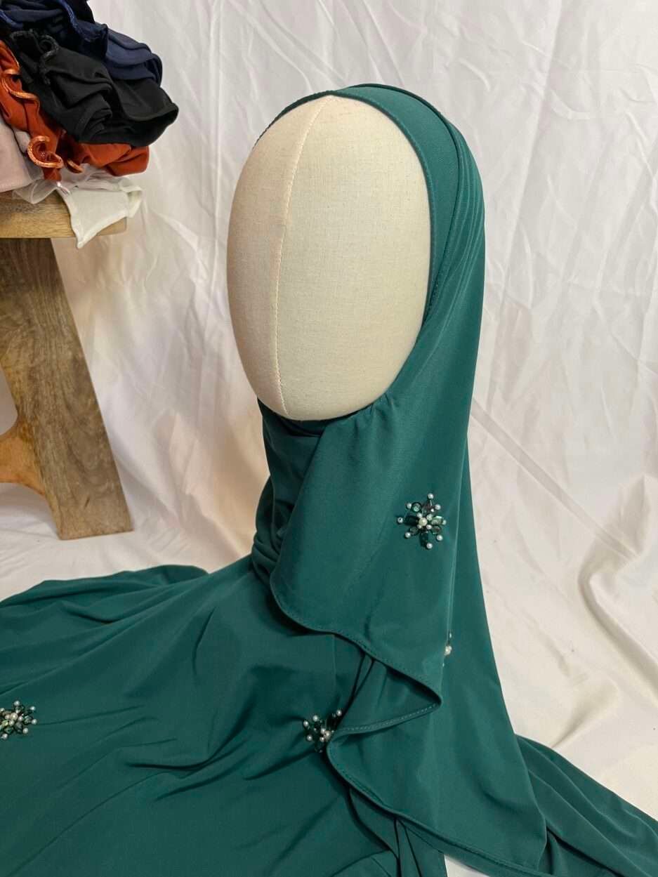 Hijab prêt-à-porter vert émeraude en jersey avec appliques de perles et strass, vue de côté sur mannequin - Iklilboutique.com