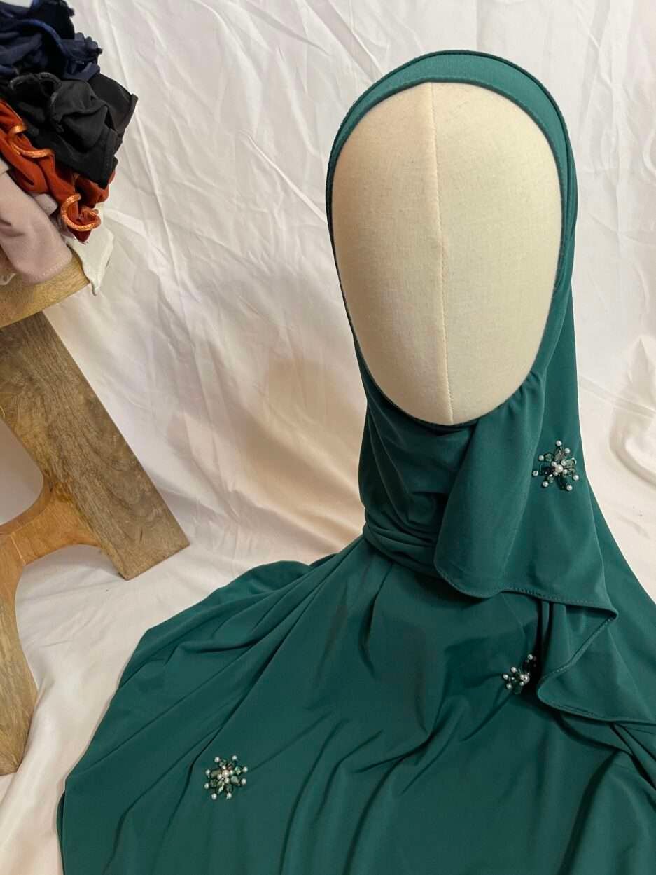 Hijab prêt-à-porter vert émeraude en jersey avec appliques de perles et strass, vue de côté sur mannequin - Iklilboutique.com