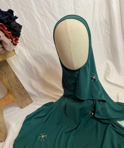 Hijab vert émeraude uni en jersey doux, orné de broches de perles et strass, présenté sur un mannequin.