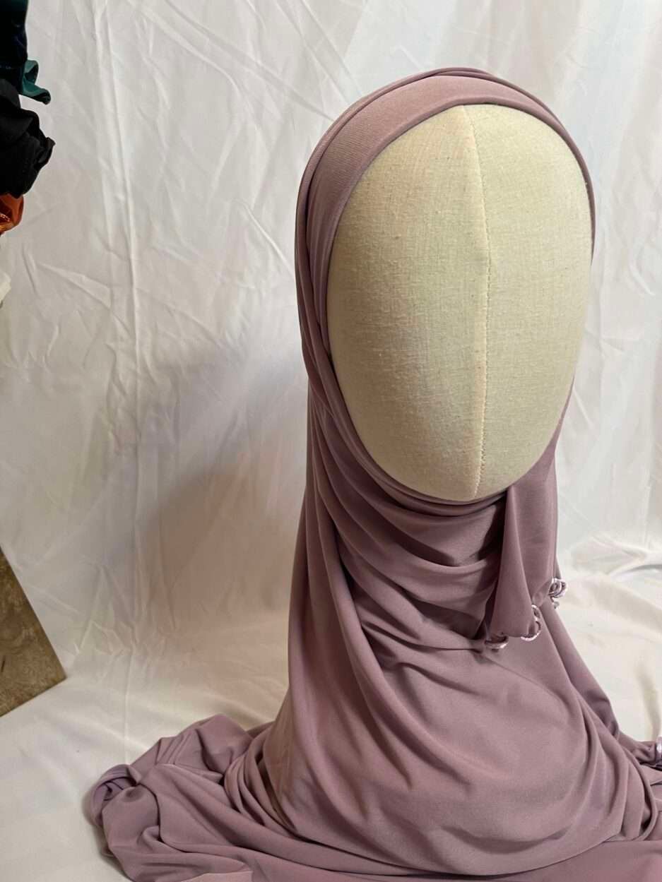 Hijab mauve poudré uni en jersey doux avec une fine bordure festonnée contrastante, présenté sur un mannequin.