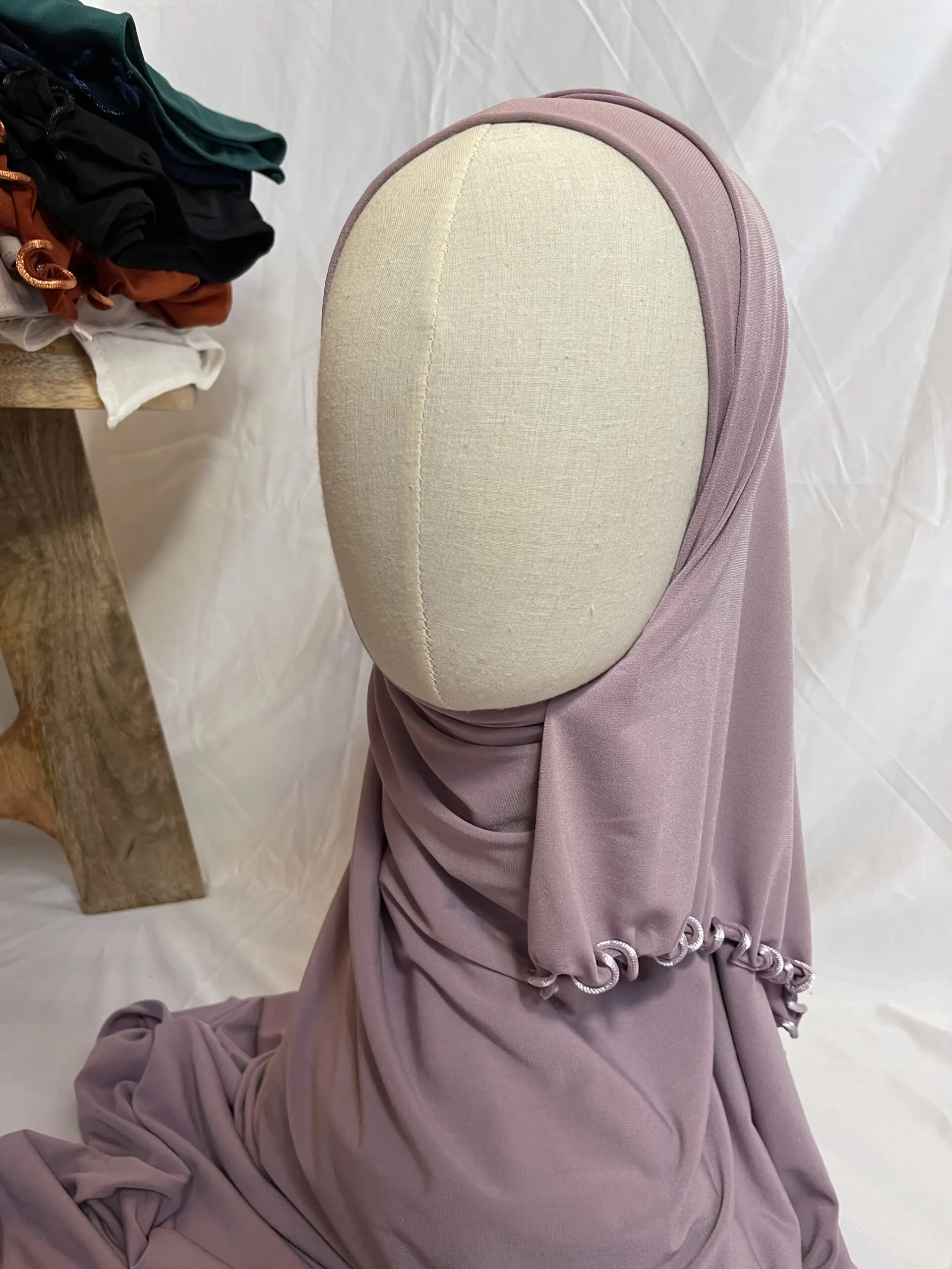 Hijab mauve poudr&eacute; uni en jersey doux avec une fine bordure festonn&eacute;e contrastante, pr&eacute;sent&eacute; sur un mannequin.