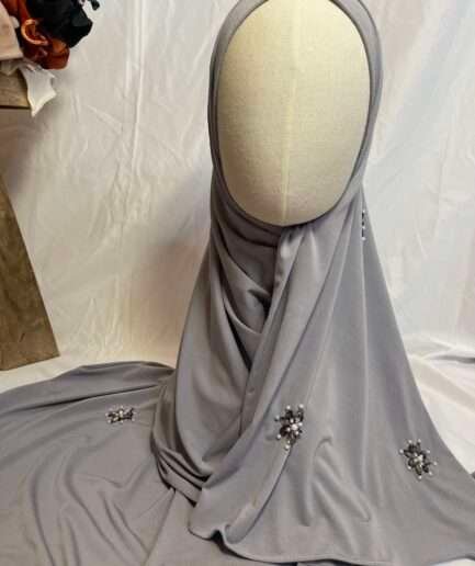 Hijab gris perle uni en jersey doux, orné de broches effet diamant (perles et strass), présenté sur un mannequin.