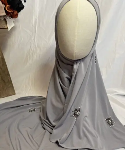 Hijab gris perle uni en jersey doux, orn&eacute; de broches effet diamant (perles et strass), pr&eacute;sent&eacute; sur un mannequin.