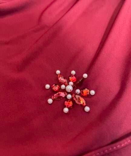 Hijab rouge bordeaux uni en jersey doux, orné de broches effet rubis (perles et strass rouges), présenté sur un mannequin.