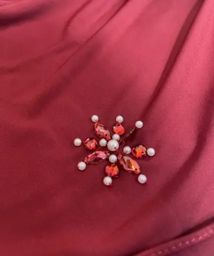 Hijab rouge bordeaux uni en jersey doux, orn&eacute; de broches effet rubis (perles et strass rouges), pr&eacute;sent&eacute; sur un mannequin.