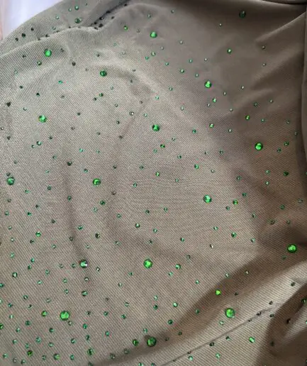 Hijab vert olive en jersey doux, parsem&eacute; de petits strass verts scintillants effet ciel &eacute;toil&eacute;, pr&eacute;sent&eacute; sur un mannequin.