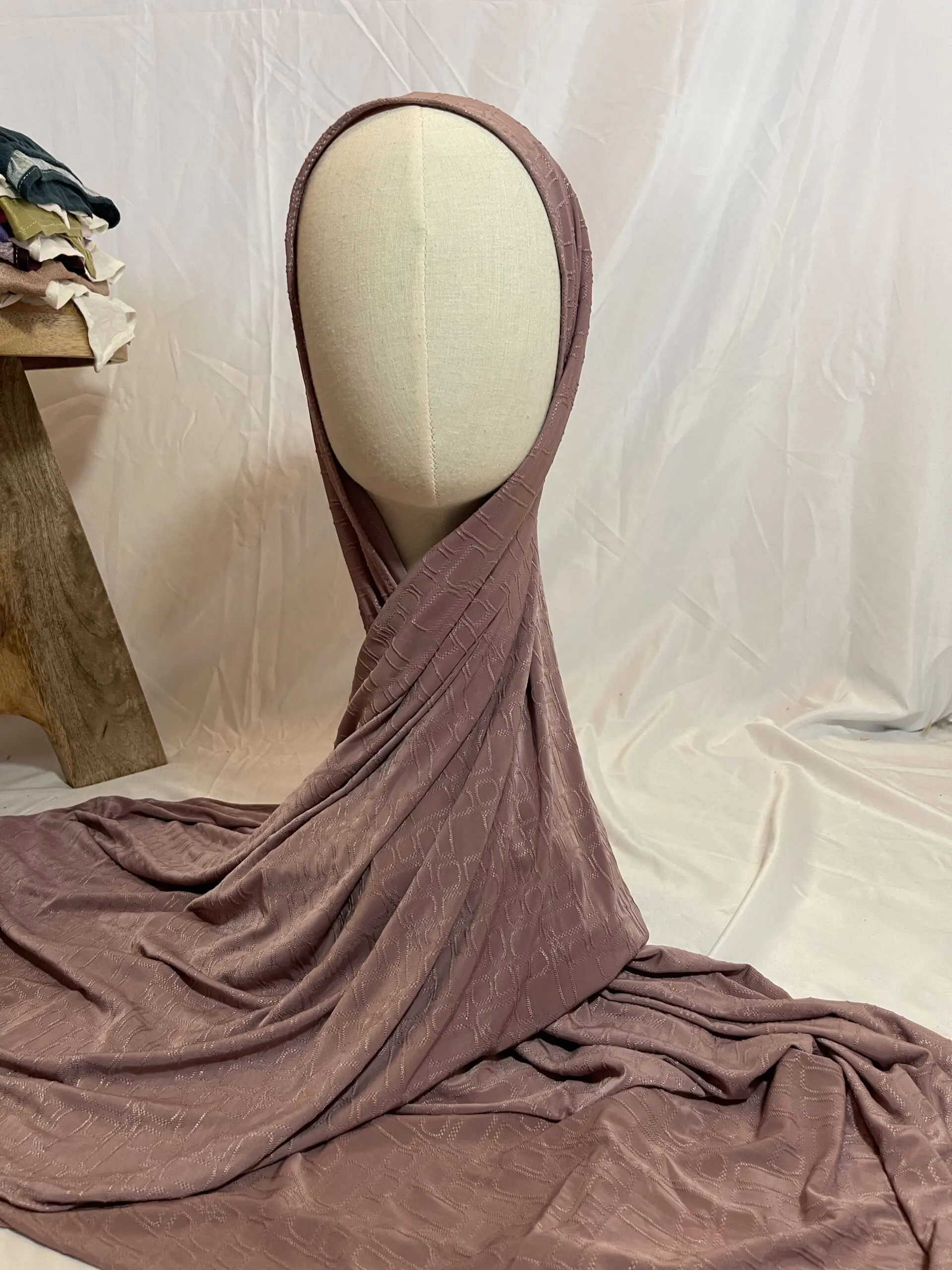 Hijab vieux rose en tissu doux avec un motif textur&eacute; en relief, pr&eacute;sent&eacute; sur un mannequin.