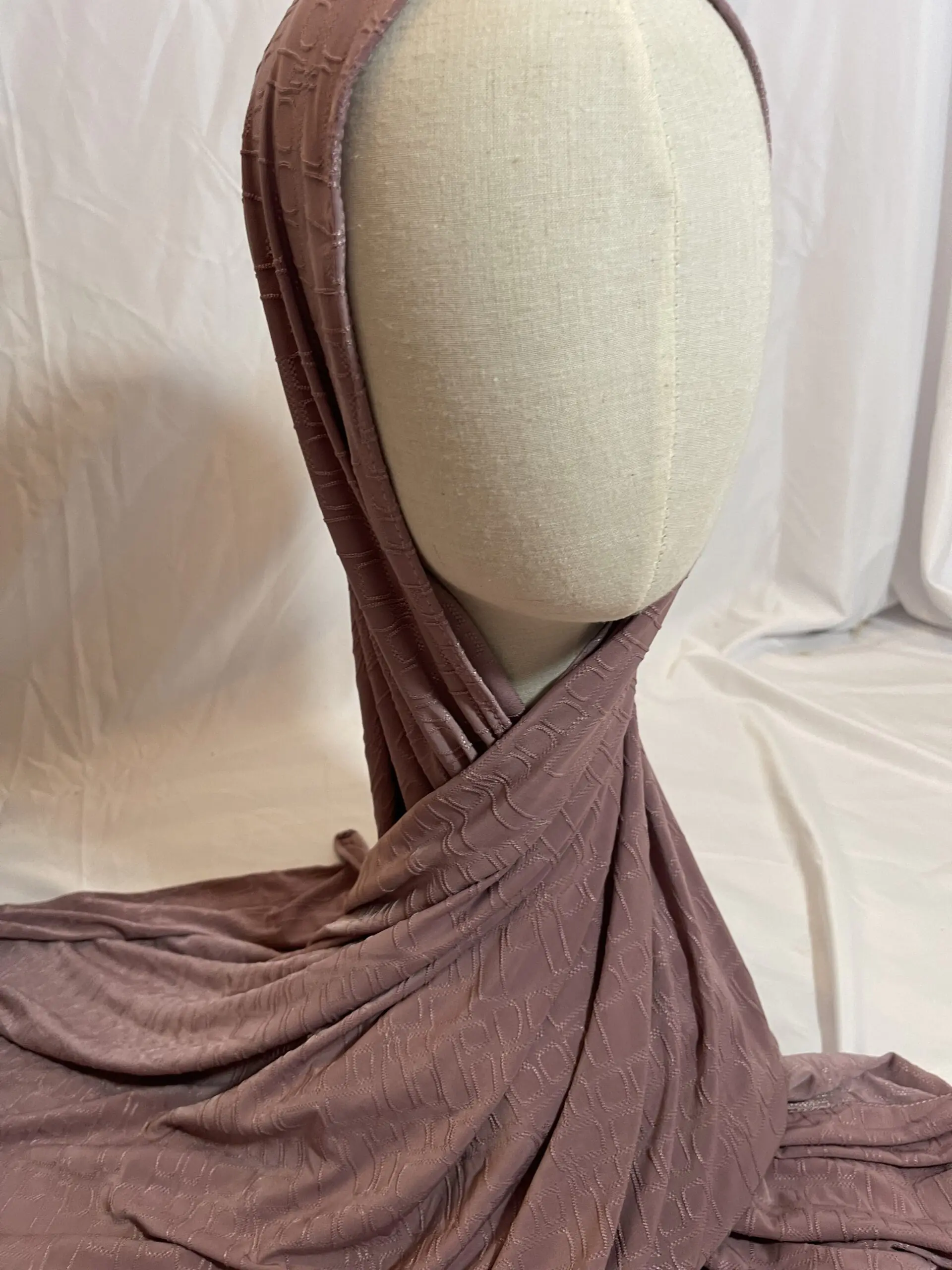 Hijab vieux rose en tissu doux avec un motif textur&eacute; en relief, pr&eacute;sent&eacute; sur un mannequin.