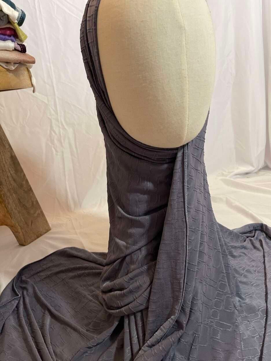Hijab gris anthracite en tissu doux avec un motif texturé en relief, présenté sur un mannequin.