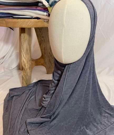 Hijab gris anthracite en tissu doux avec un motif texturé en relief, présenté sur un mannequin.