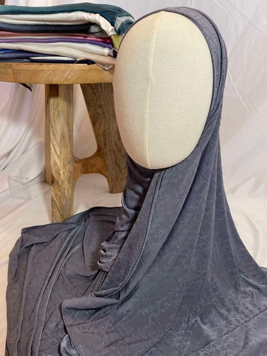 Hijab gris anthracite en tissu doux avec un motif texturé en relief, présenté sur un mannequin.